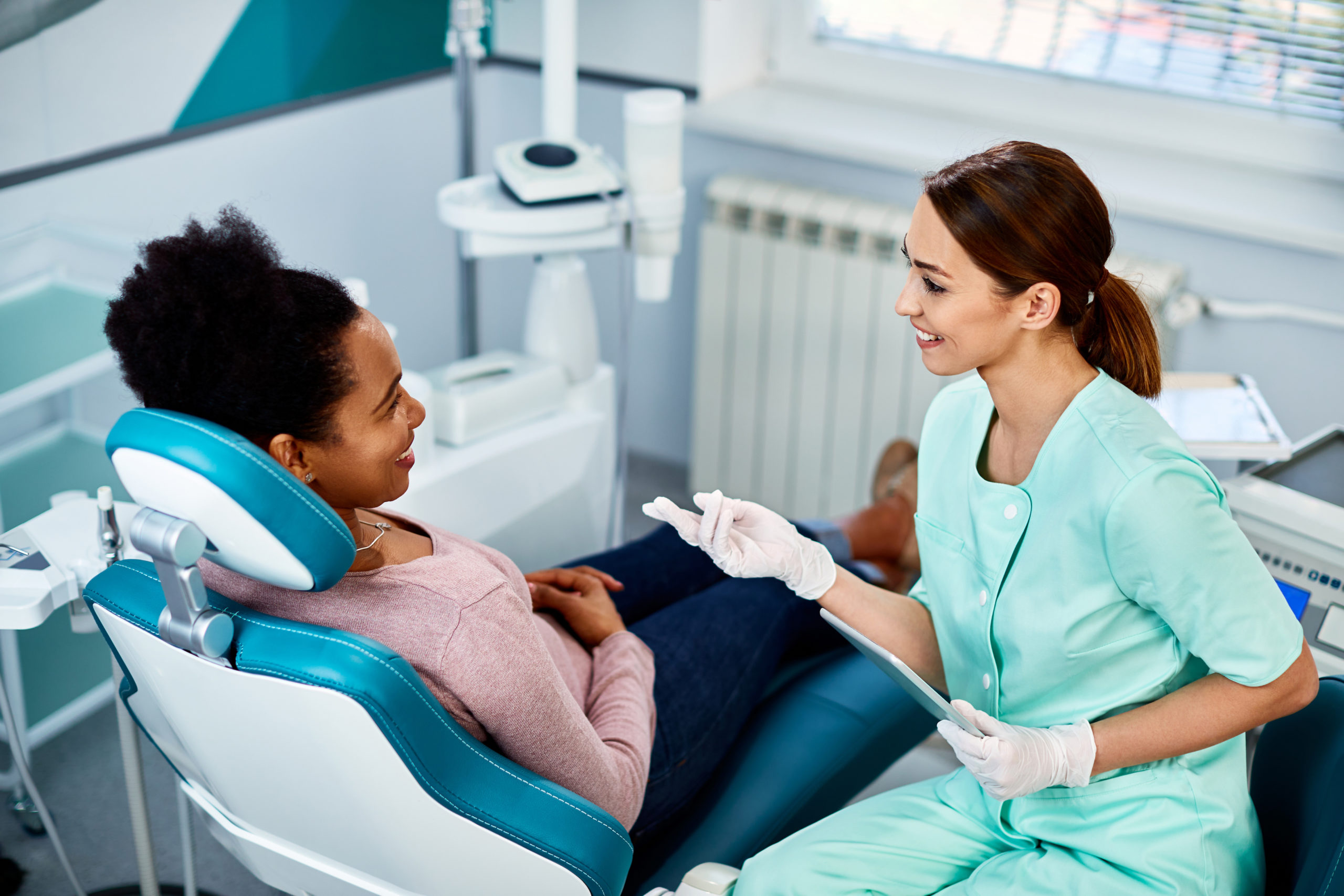 椅子に座って歯科医師の話を聞く女性患者