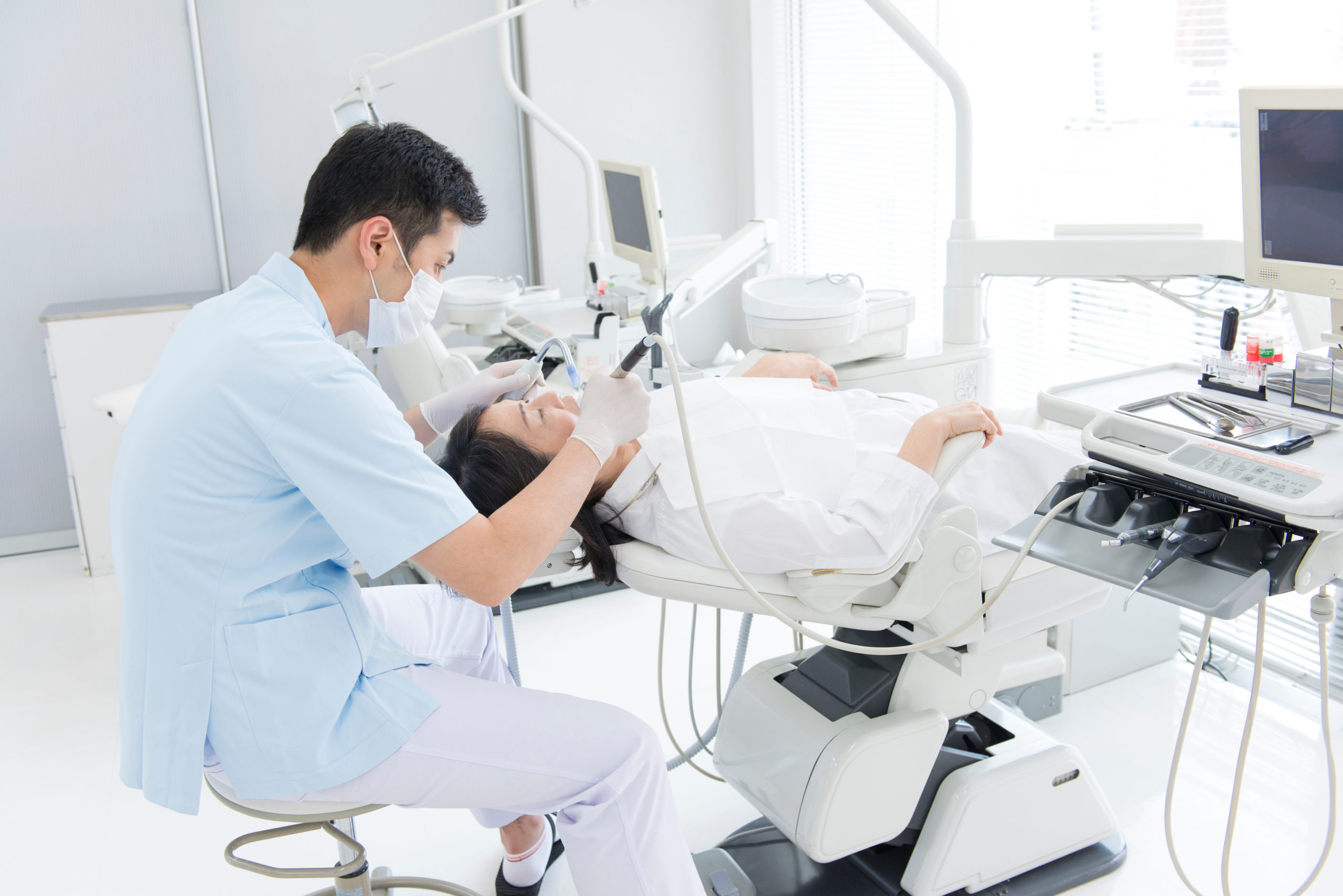 女性患者の歯の治療をする男性歯科医師
