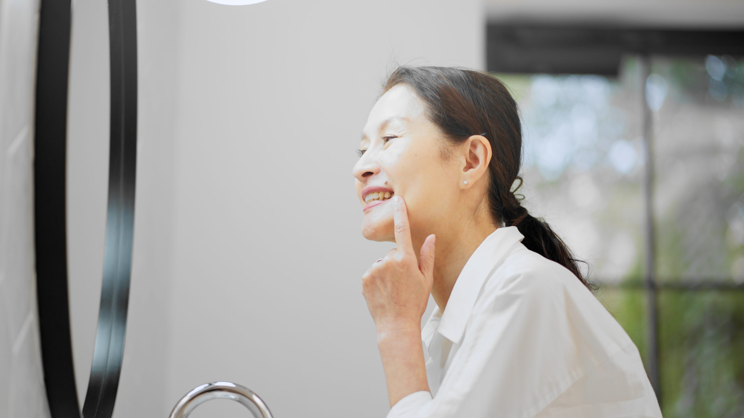 鏡で自分の歯の状態を確認する女性