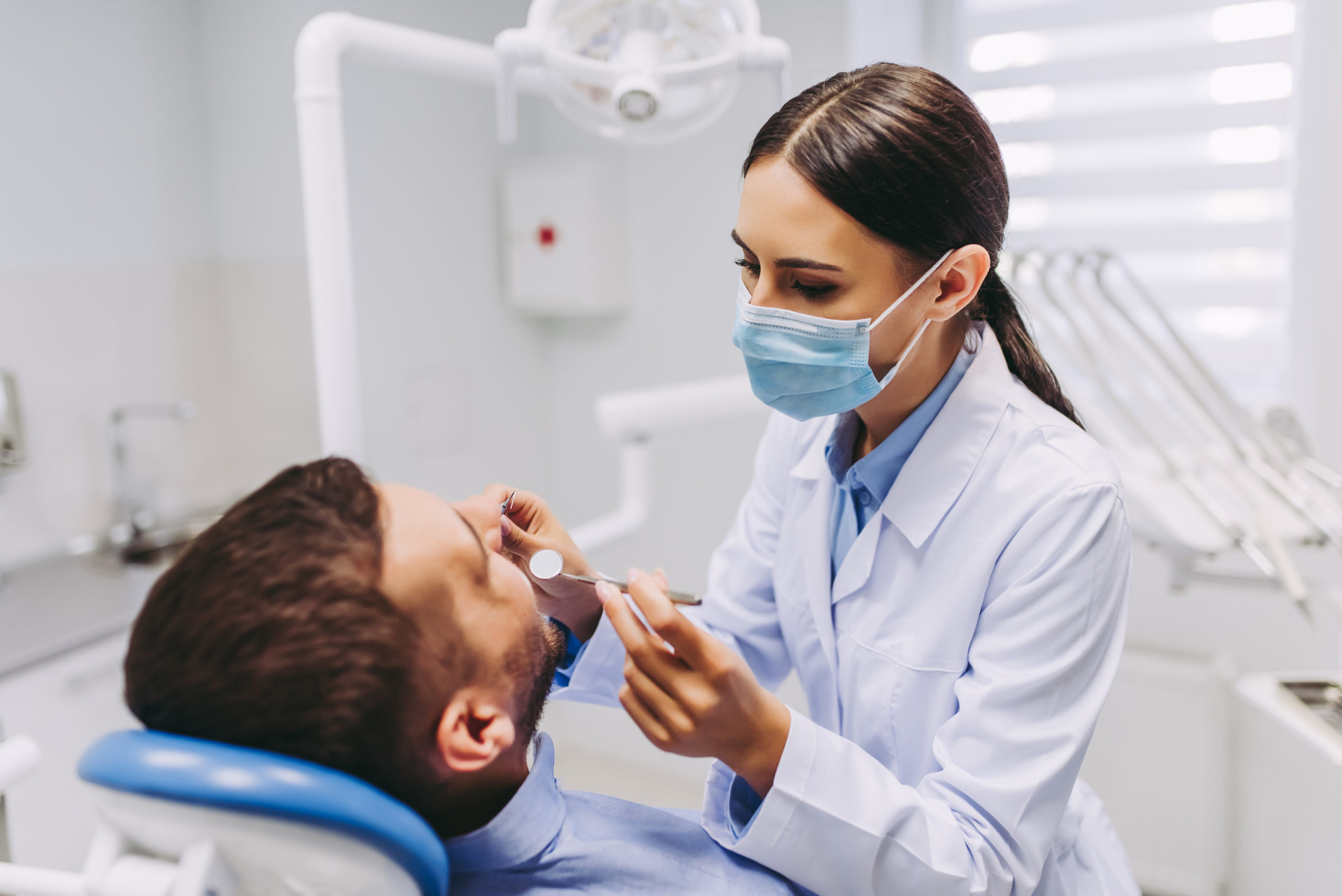 男性患者の口腔内を確認する女性歯科医師