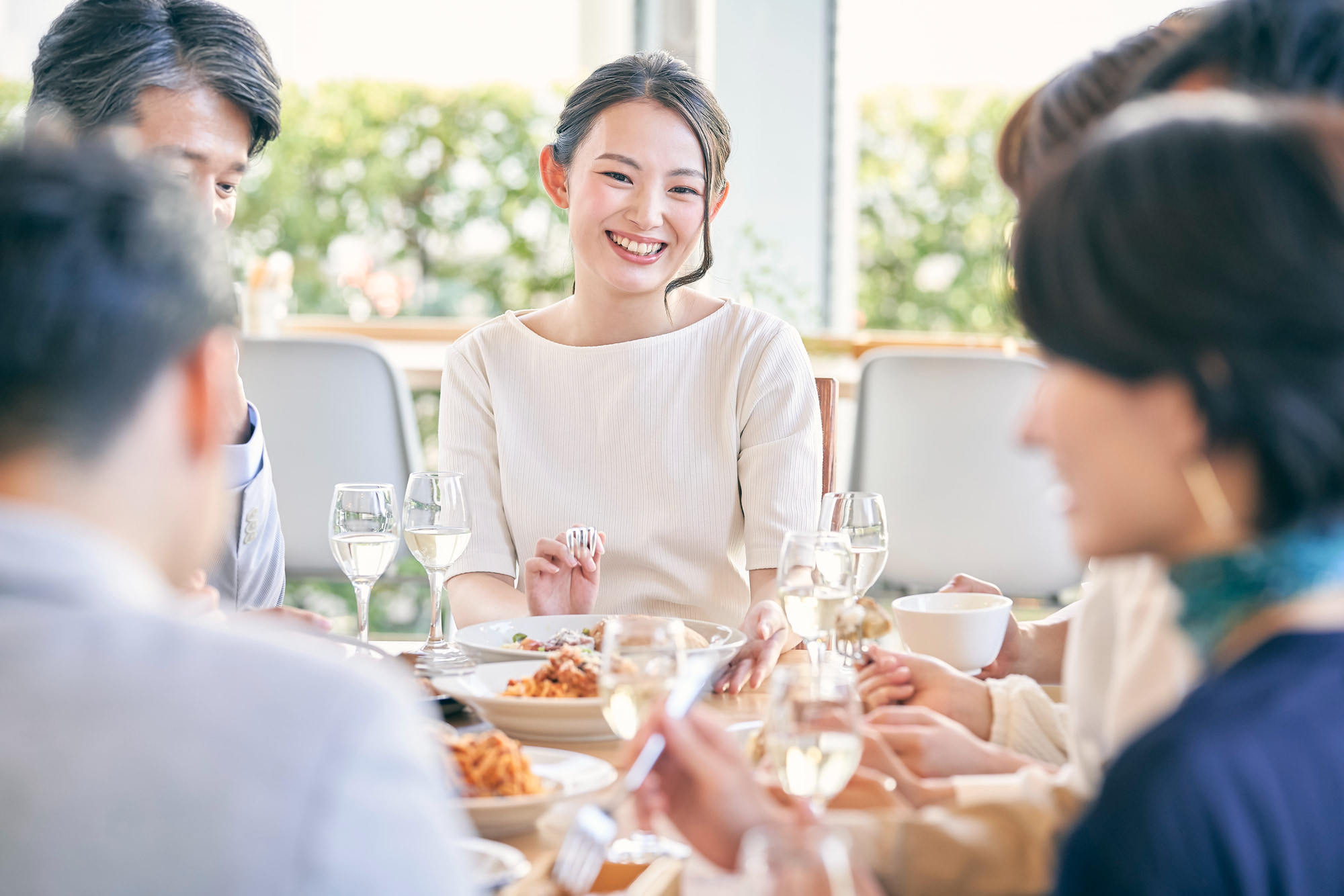 インビザラインで歯列が整い食事会を楽しむ女性