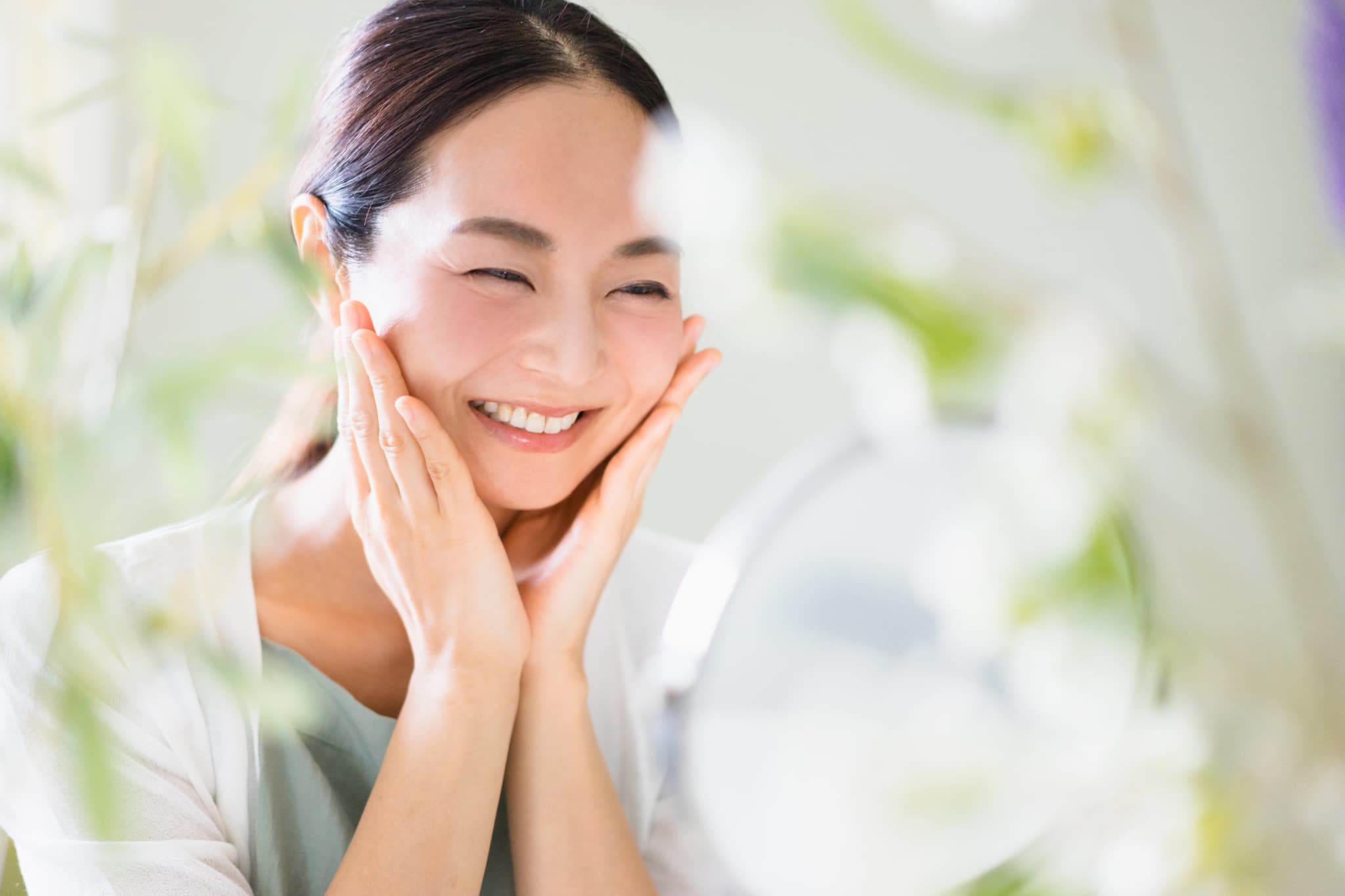 整った歯並びを鏡で確認して嬉しそうな女性