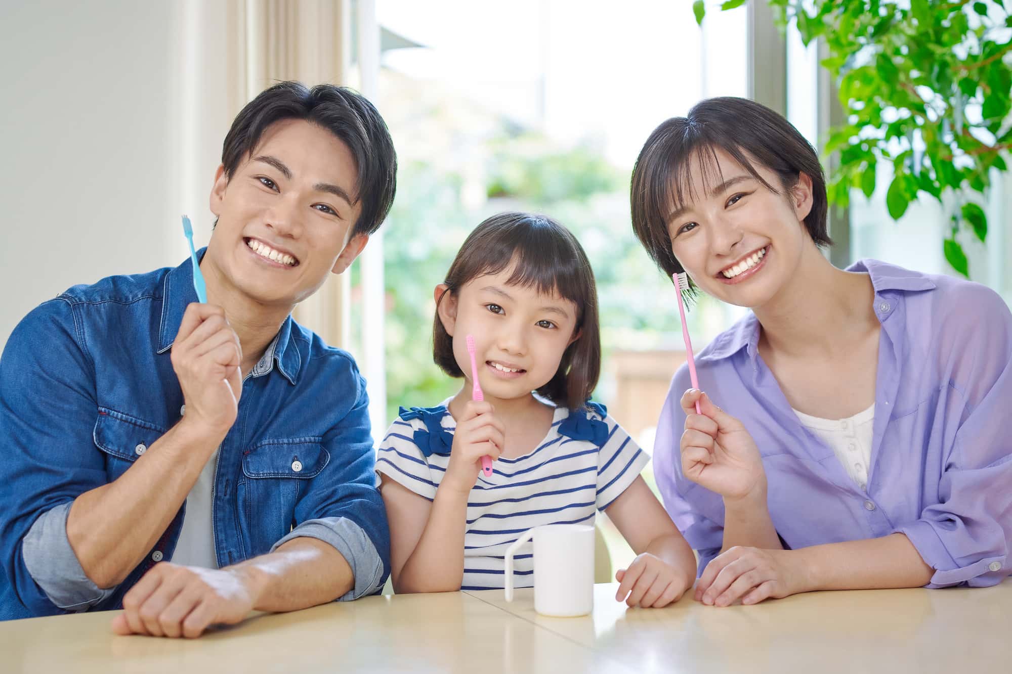 ブラッシング指導を受けた家族が歯みがきをするイメージ