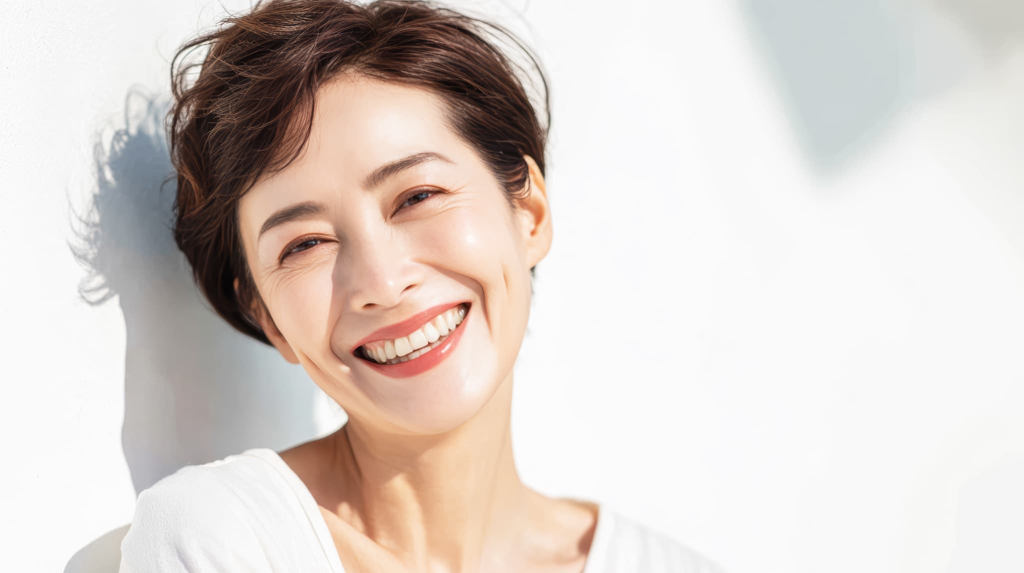 前歯に入れ歯を入れて笑顔を見せる女性