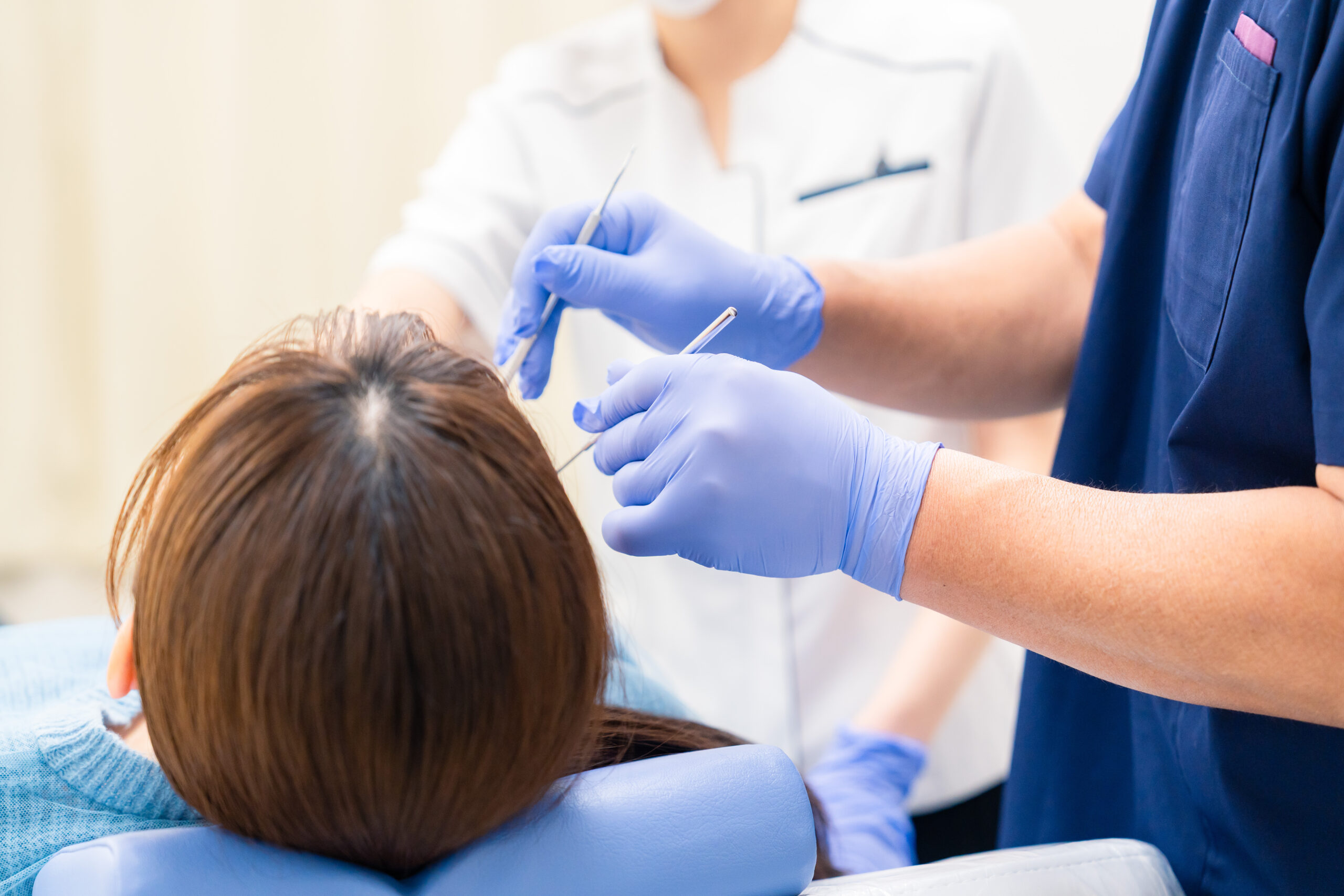 マウスピース矯正中の口臭を防ぐために歯科医院で歯科医師のケアを受けている女性