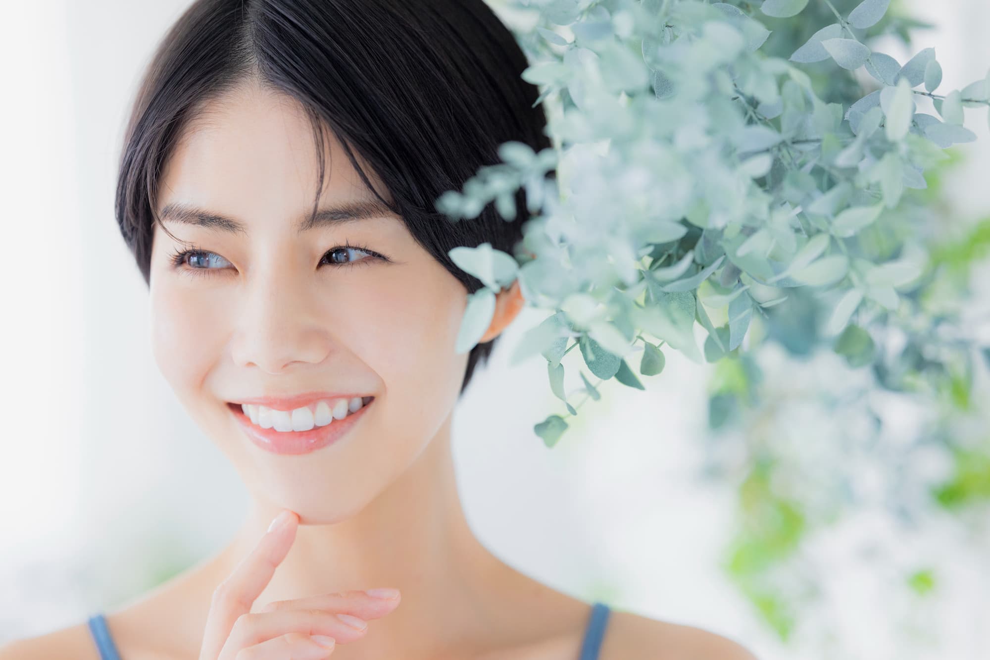 ホワイトニングをした白い歯を満足して指さす女性