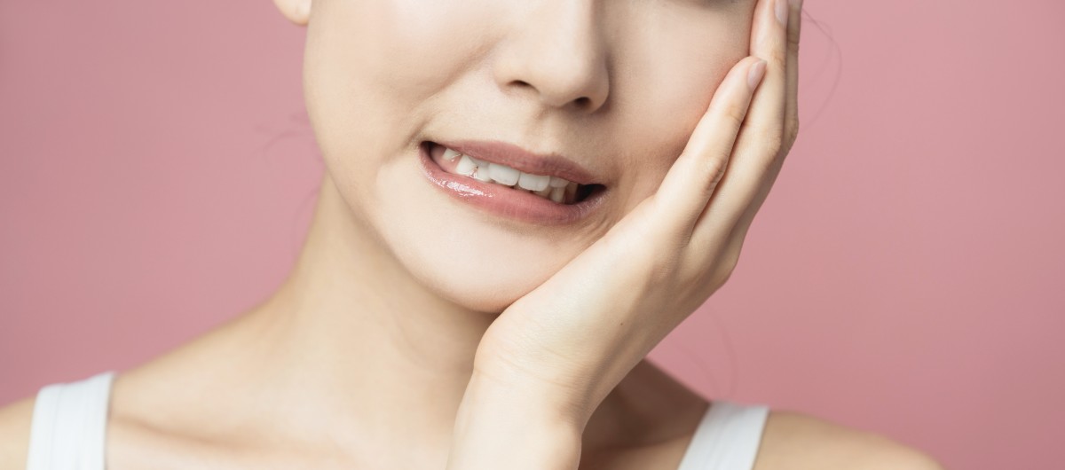 ホワイトニングで歯がしみている女性